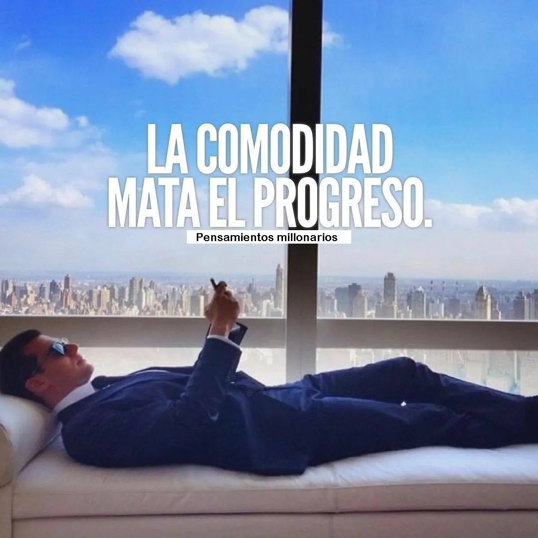 Se ve a un hombre en traje y gafas de sol, recostado en un sofá blanco en lo alto de un rascacielos. Está mirando su teléfono y la ciudad se ve de fondo.